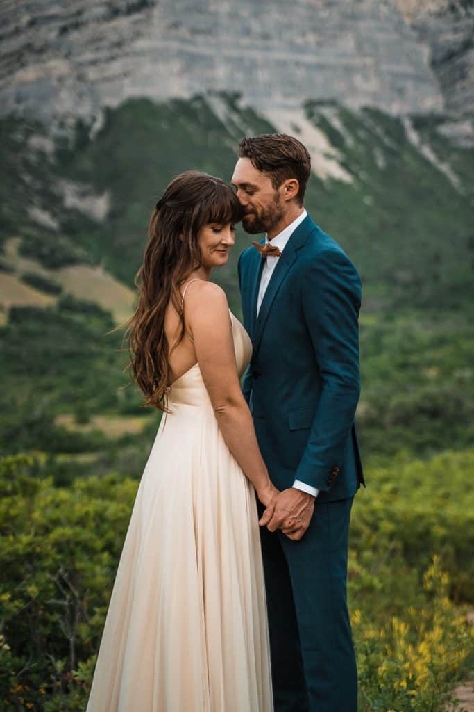 beautiful shot of couple holding hands facing each other with mountains in the background