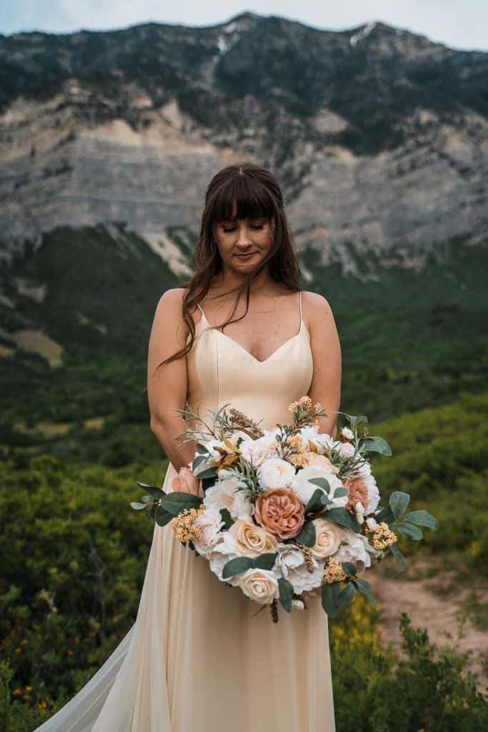 bride holding bouquet with mountains in background in provo canyon Utah 