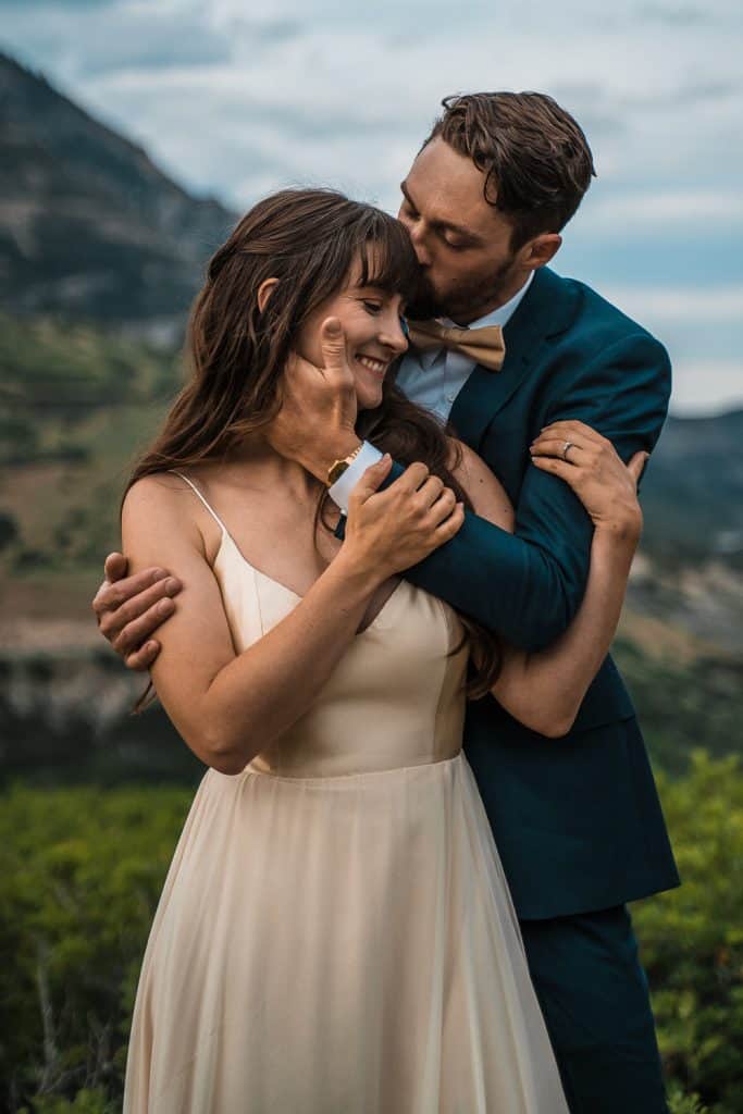 groom kissing brides head