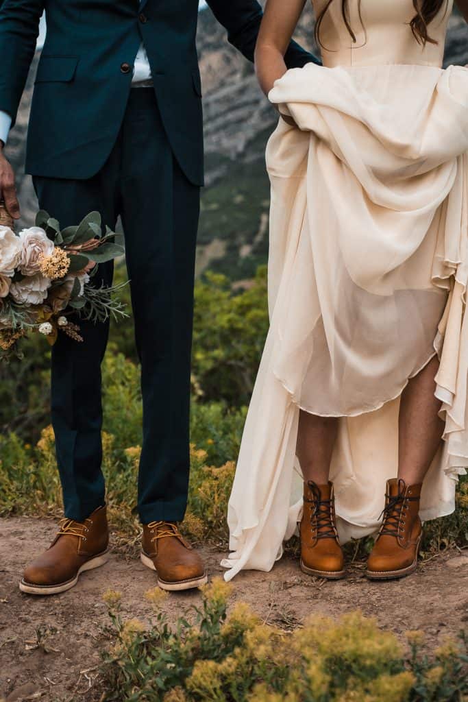 shot of couples shoes, bride lifting dress to show hiking boots