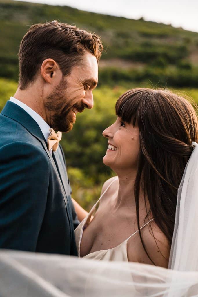 couple smiling at each other with veil in shot