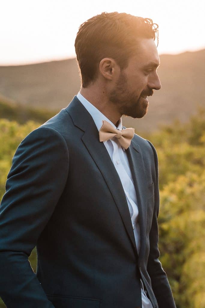 portrait shot of groom with golden sun bathing over him