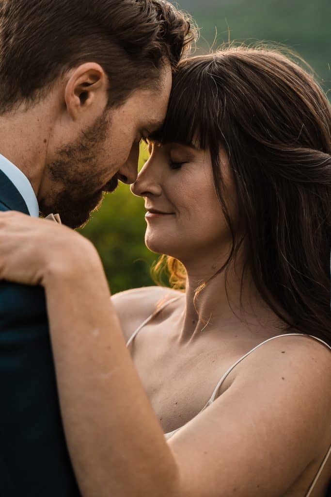 couple leaning close together facing each other, bride smiling 