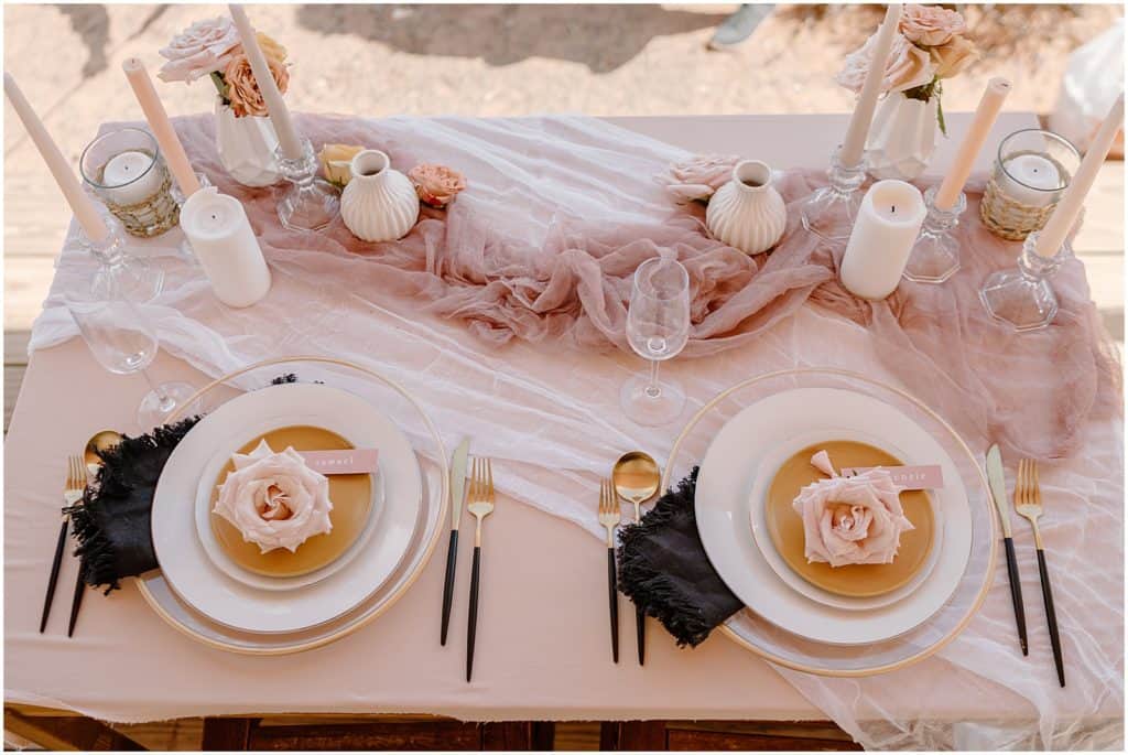sweetheart table with pink, black, and gold details and lots of candles and ceramics