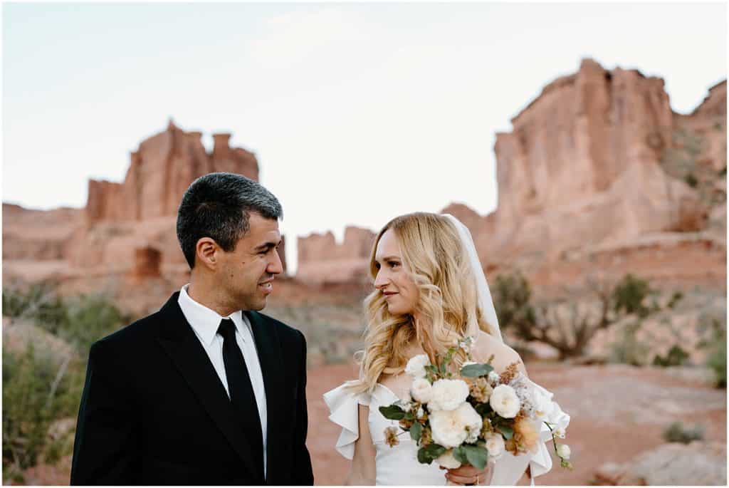 couple after their first look in moab for their elopement. up close to camera looking at each other.
