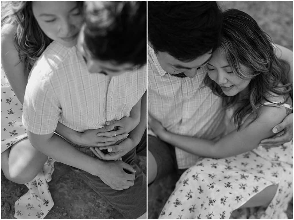 photo of couple sitting on ground and hugging in black and white