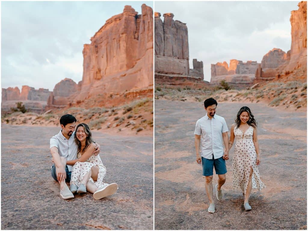 sunrise photo shoot of couple sitting on the ground and holding hands on their adventure session in the arches national park