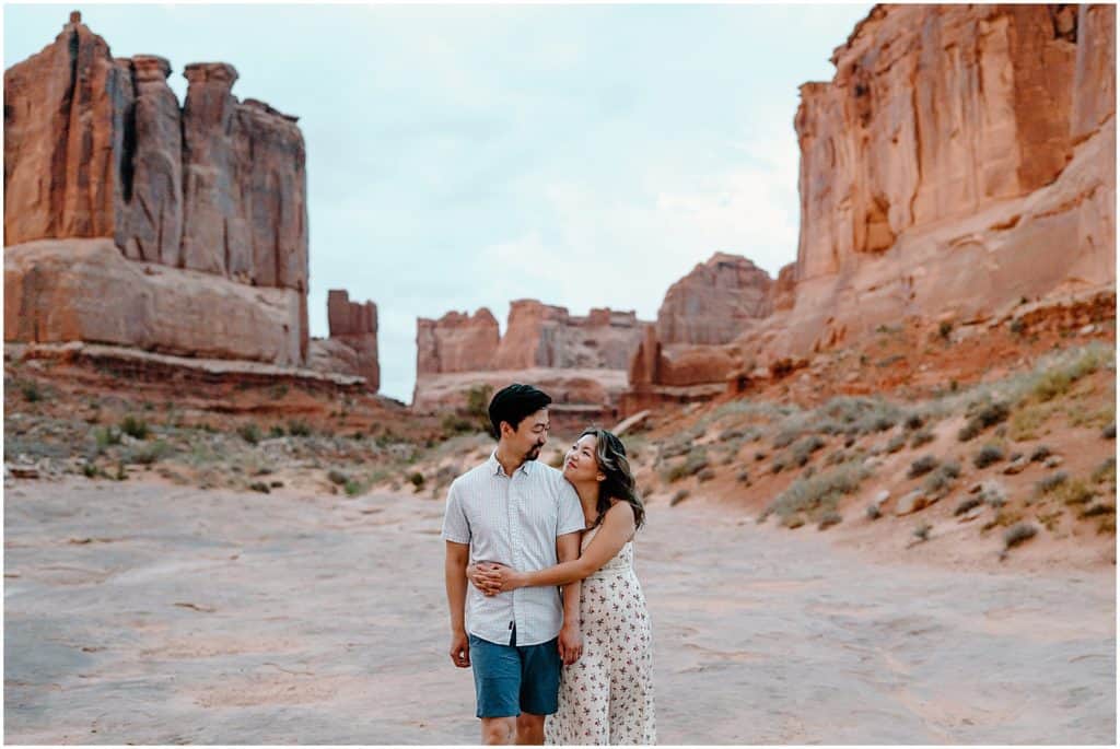 sunrise photoshoot of couple embracing on their adventure session in the arches national park