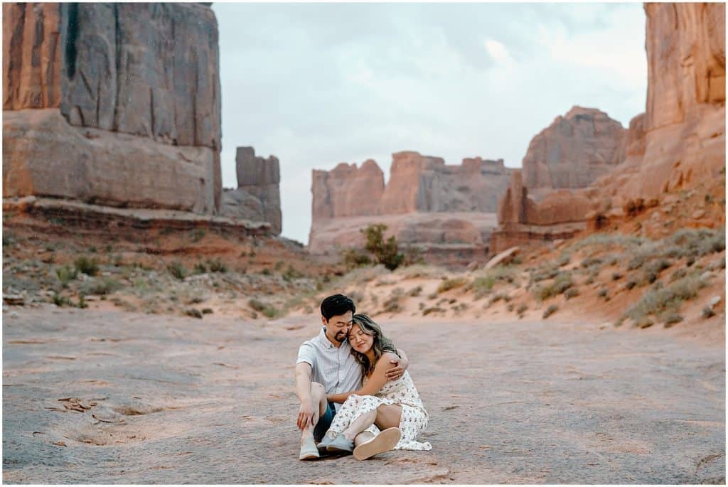 Couple seen in the front with the background blurry on their Arches National Park Adventure Session