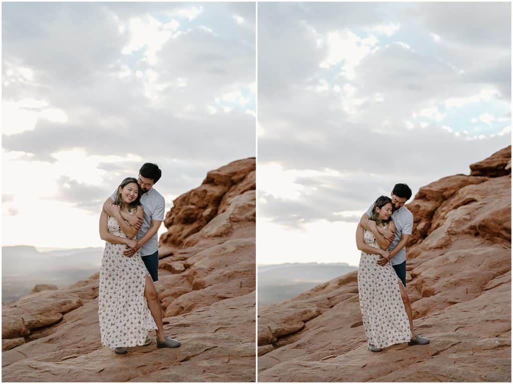 couple under slot canyon in utah on their adventure session in the arches national park