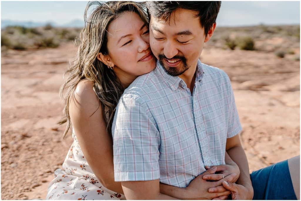 photo of couple sitting on ground and hugging