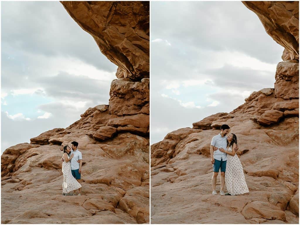 couple under slot canyon in utah on their adventure session in the arches national park