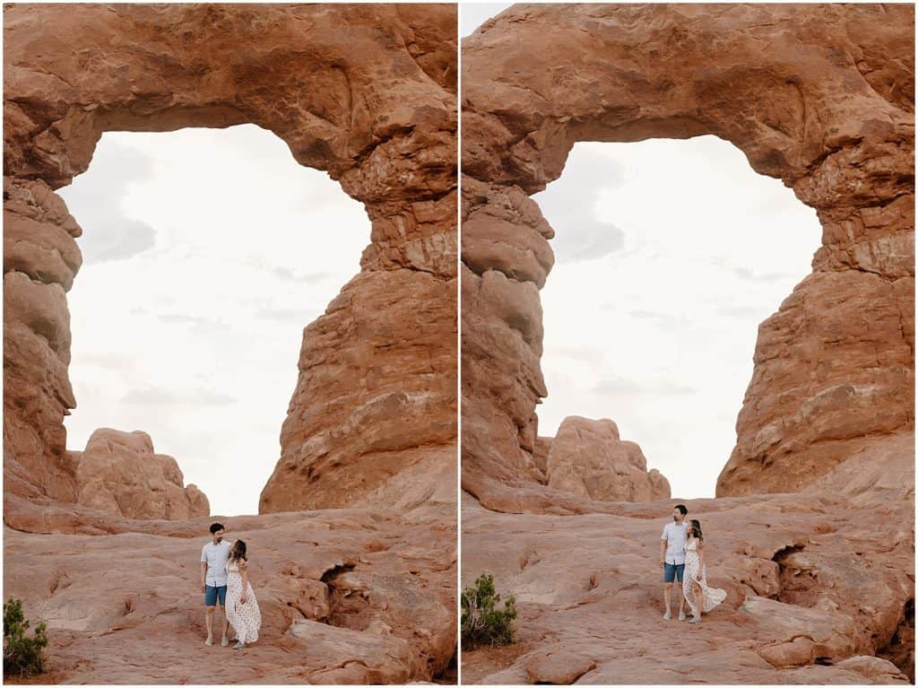 couple under slot canyon in utah on their adventure session in the arches national park