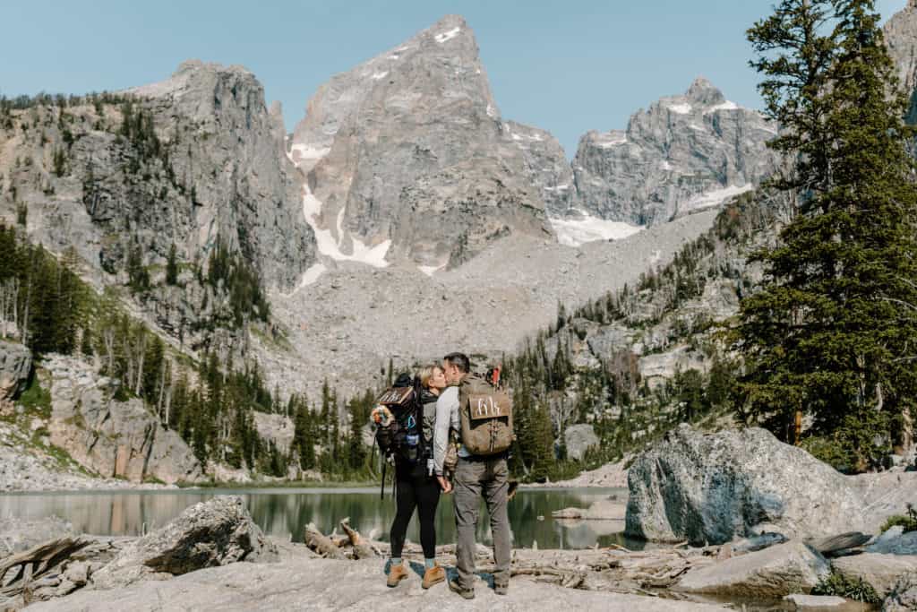 Eloping in an epic location–like this couple who kisses against the backgdrop of the Grand Tetons in Wyoming–is an epic reason to. consider eloping.