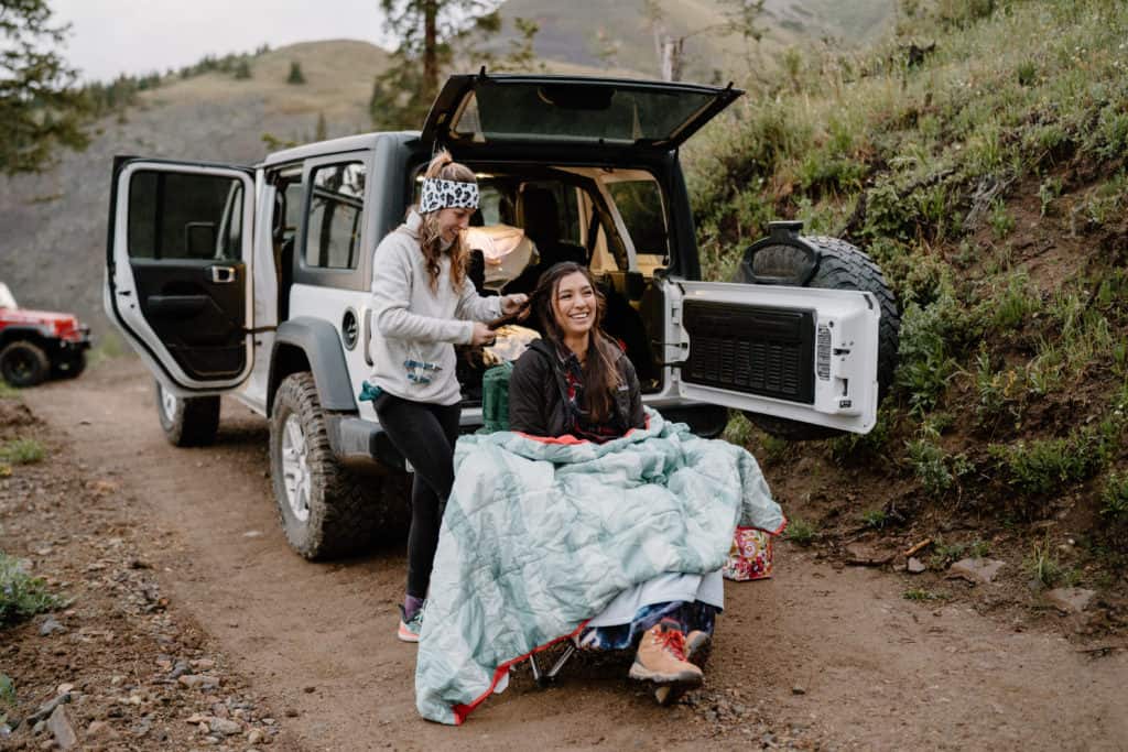 The bride, Ana, finishes getting ready on the trail before her sunrise Colorado elopement begins. 