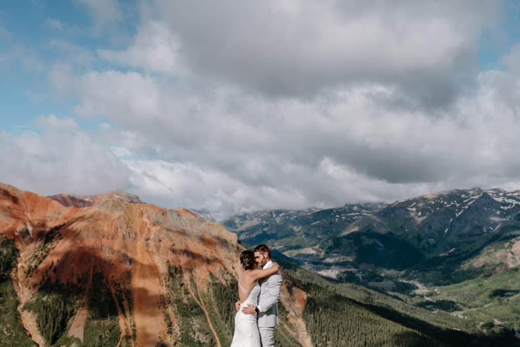 A couple embraces during their Colorado elopement high up in the mountains of the San Juan Range. 