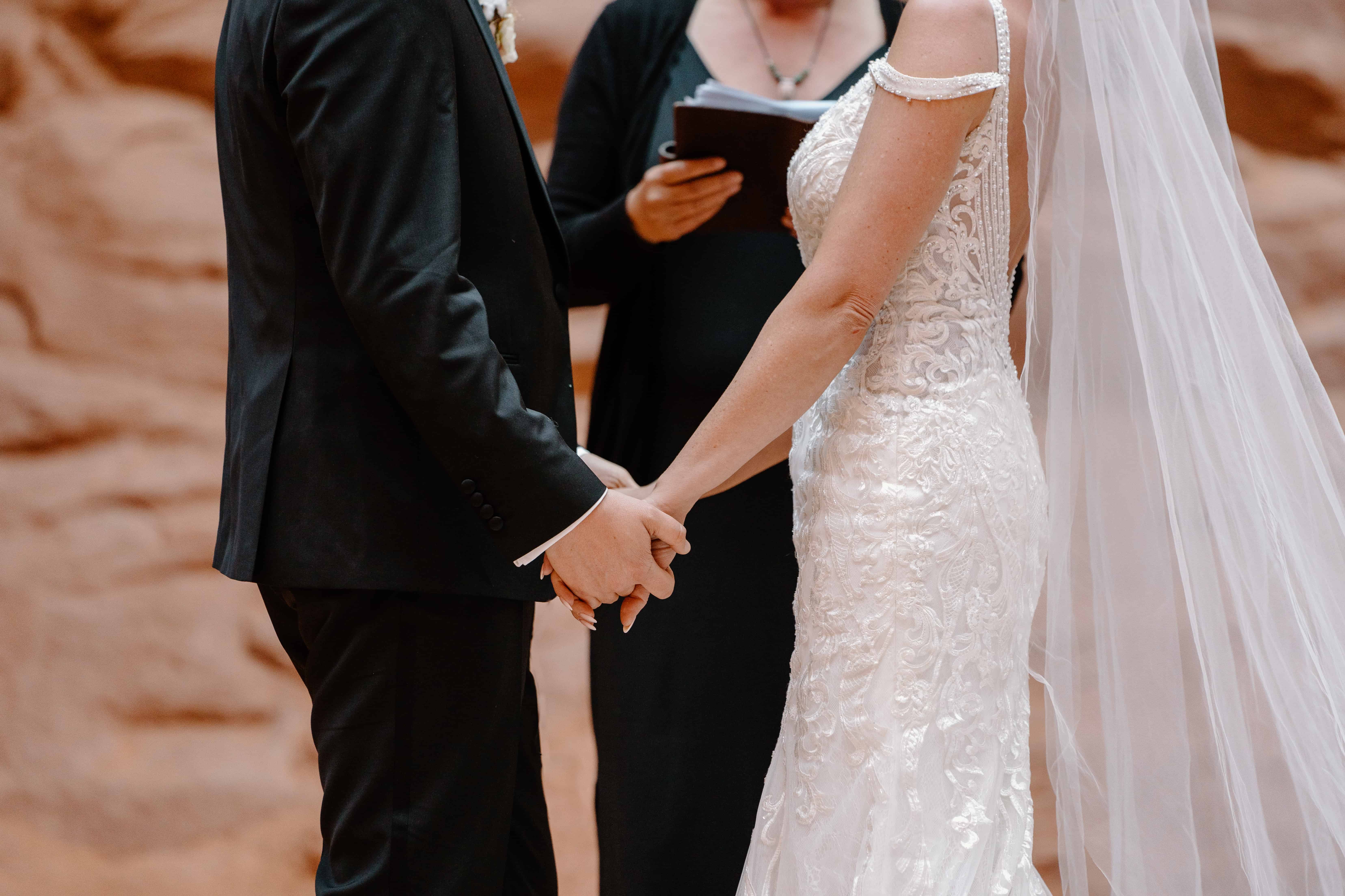 A bride and groom take hands as they experience their Moab, Utah elopement.