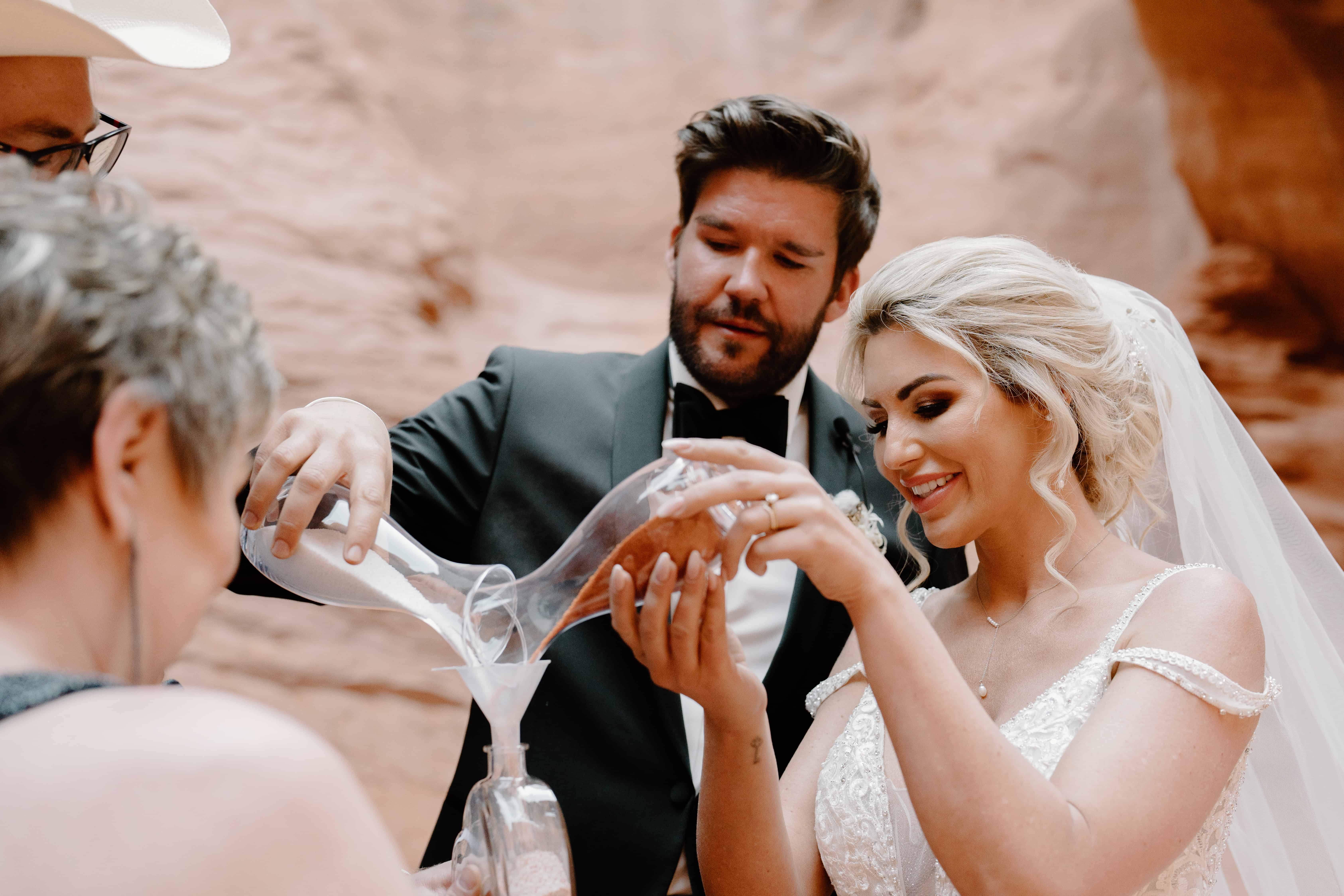 A couple blends sand as part of their unique elopement ceremony in Souther Utah. 