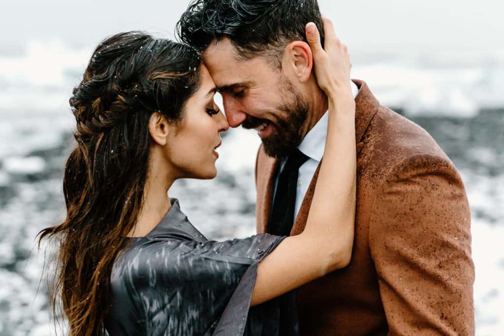 A couple holds each other close during their elopement photos in Iceland. Their Iceland elopement ceremony was on a glacial lagoon. 