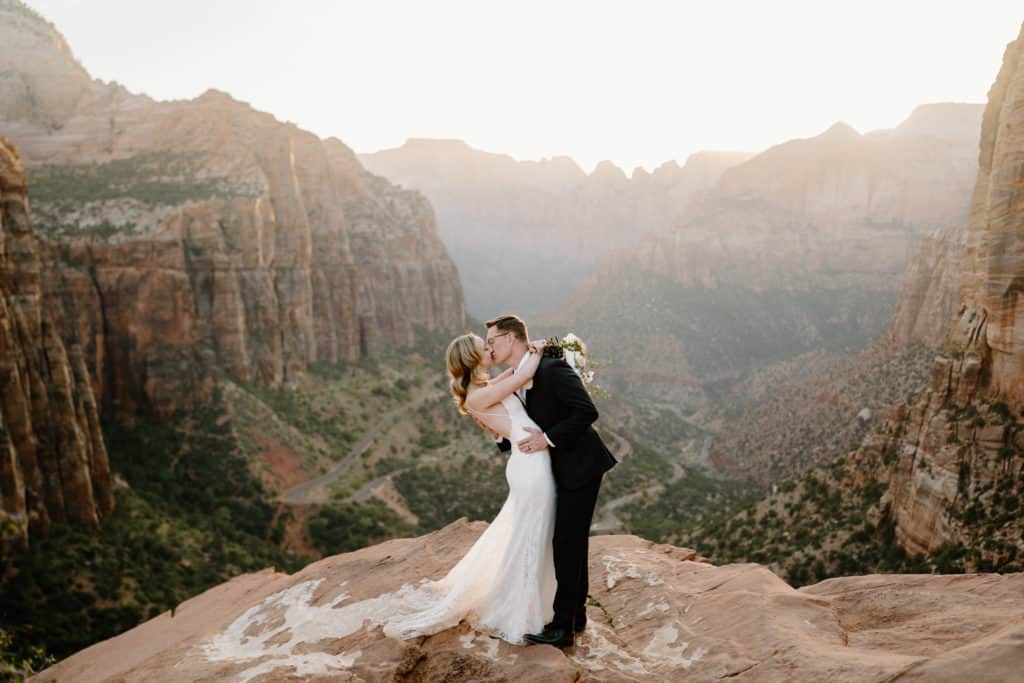 A bride and groom kiss during their Zion National Park elopement at Overlook Trail. 