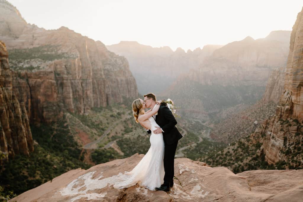 A couple leans in for a kiss on their elopement day, posing for elopement photos that will become heirlooms.