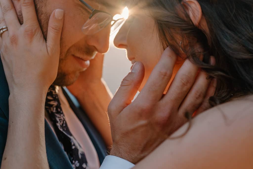 A couple holds each other's face during their elopement ceremony. 