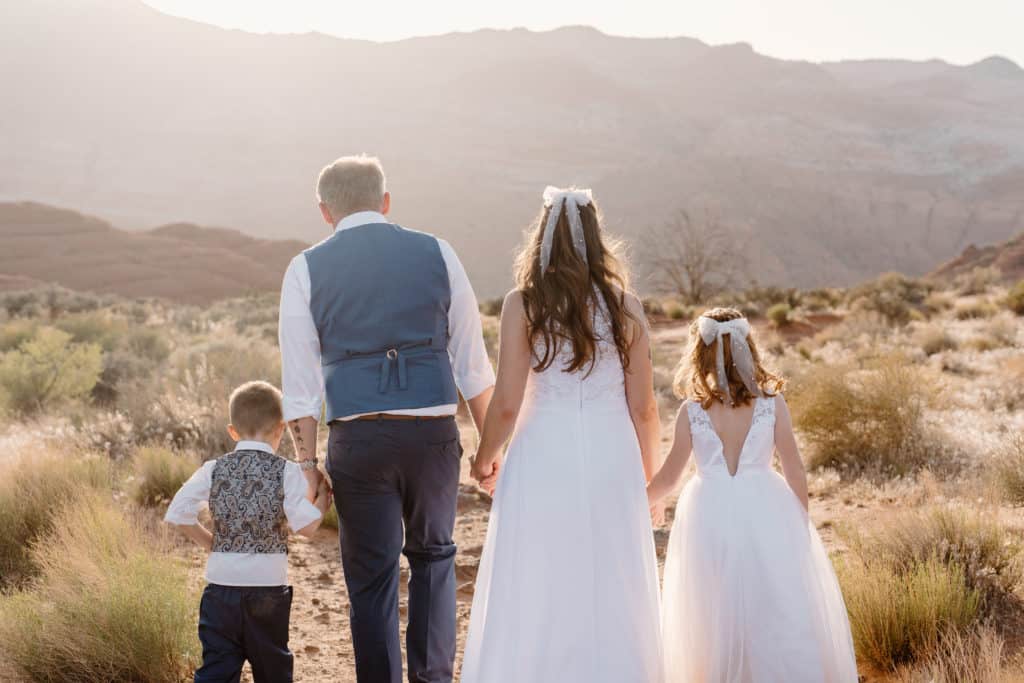 A family of four walk among the desert during their adventure elopement session in Utah. 