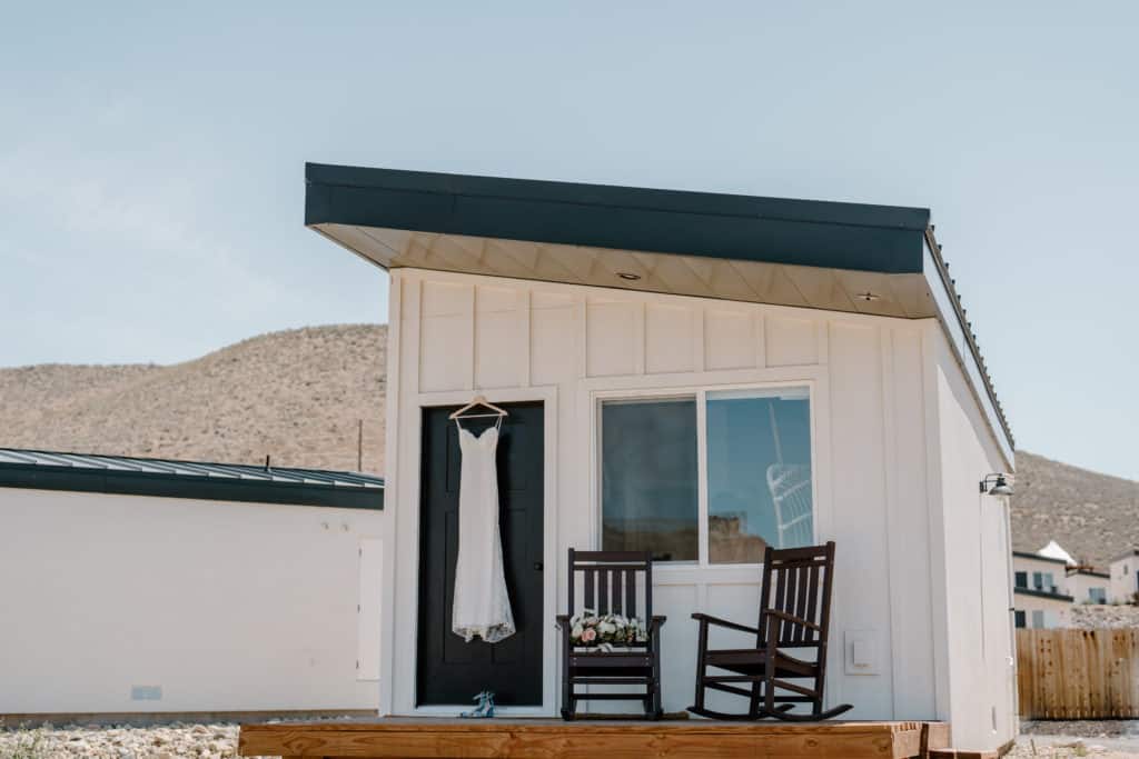 A wedding dress hangs from a tiny home in Southern Utah before a couple's Zion National Park elopement. 