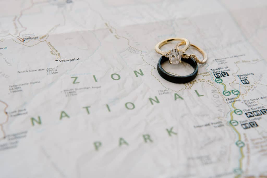 A couple's two rings are set down over the map of Zion National Park, where a couple will have their southern Utah elopement. 