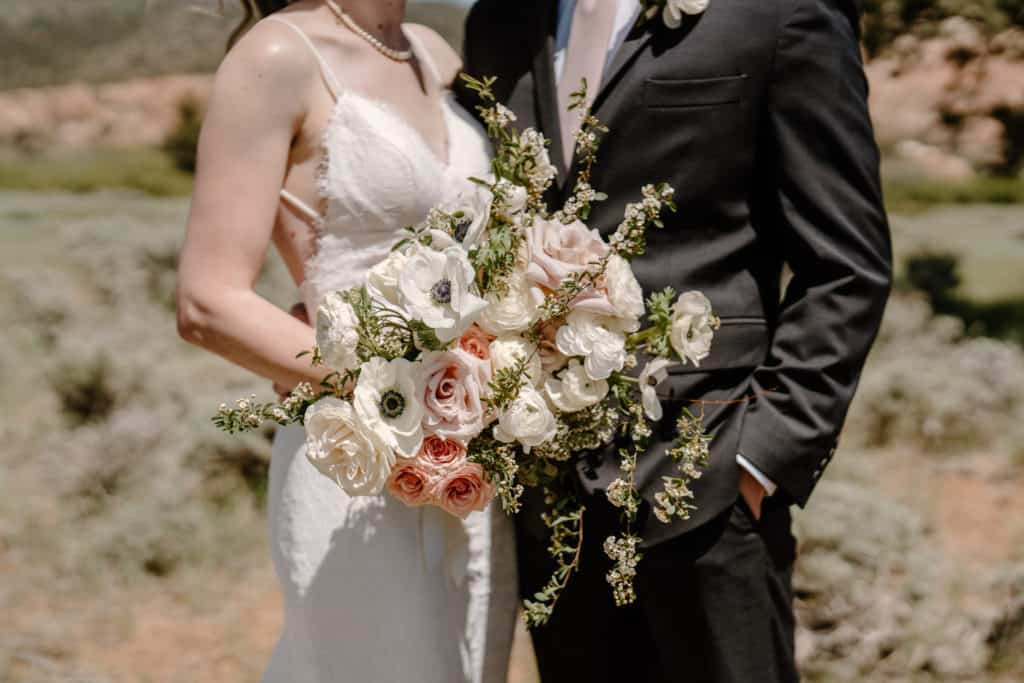 A bride and groom show off their florals during their Zion National Park elopement. 