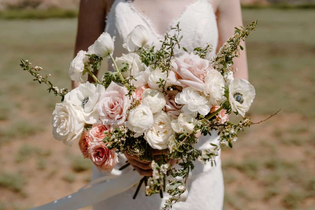 A bride shows off her gorgeous wedding flowers during her Zion National Park elopement. 