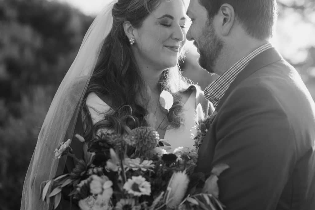 A bride and groom nuzzle in close to each other during a sunrise ceremony in Wyoming. 