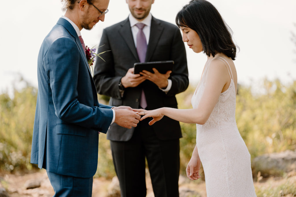 A groom gives the bride her wedding ring during their Grand Teton National Park elopement ceremony. 