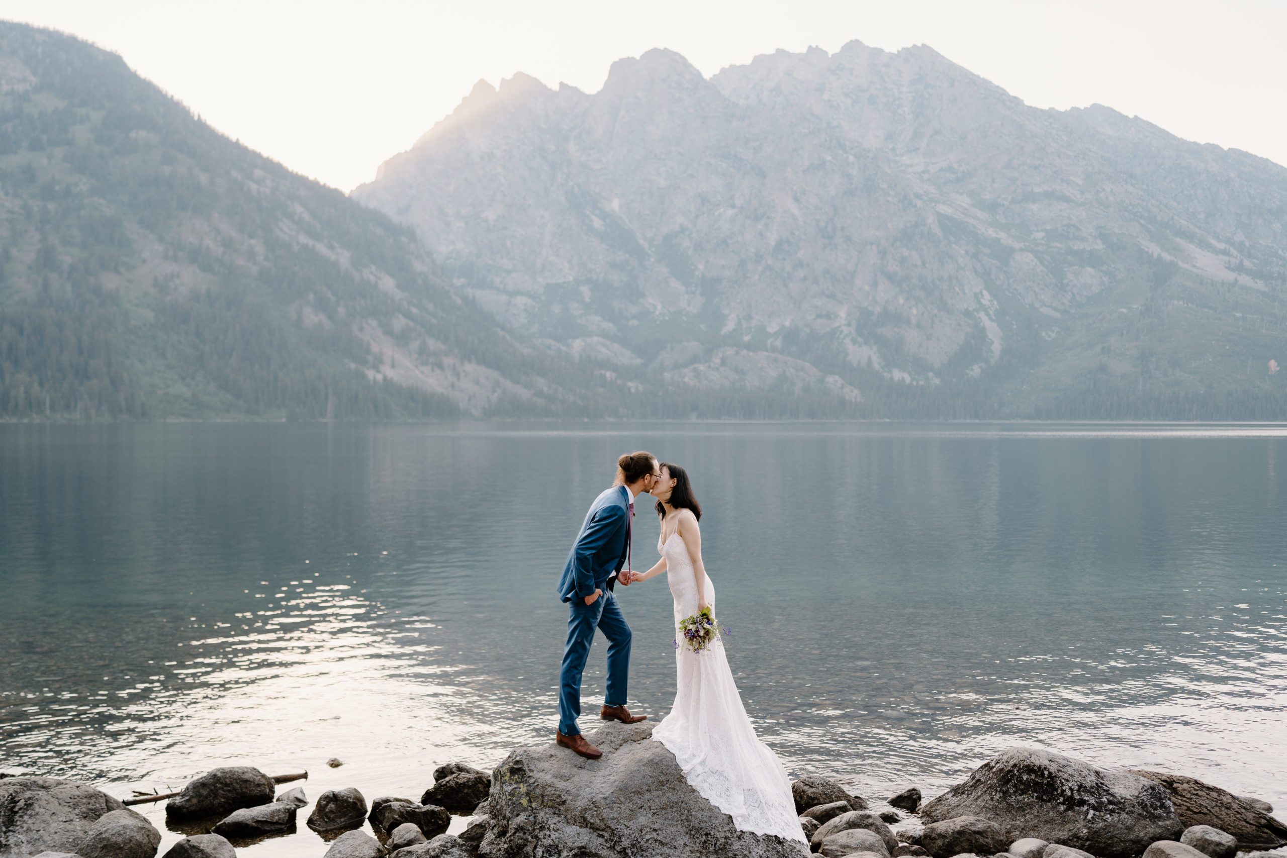 Dami and Josh, a newlywed couple, kiss each other as they explore during their Grand Teton National Park elopement.