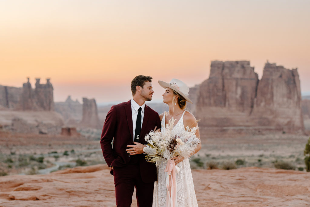 A bride and groom gaze lovingly into each other's eyes during their Utah Moab elopement ceremony. 