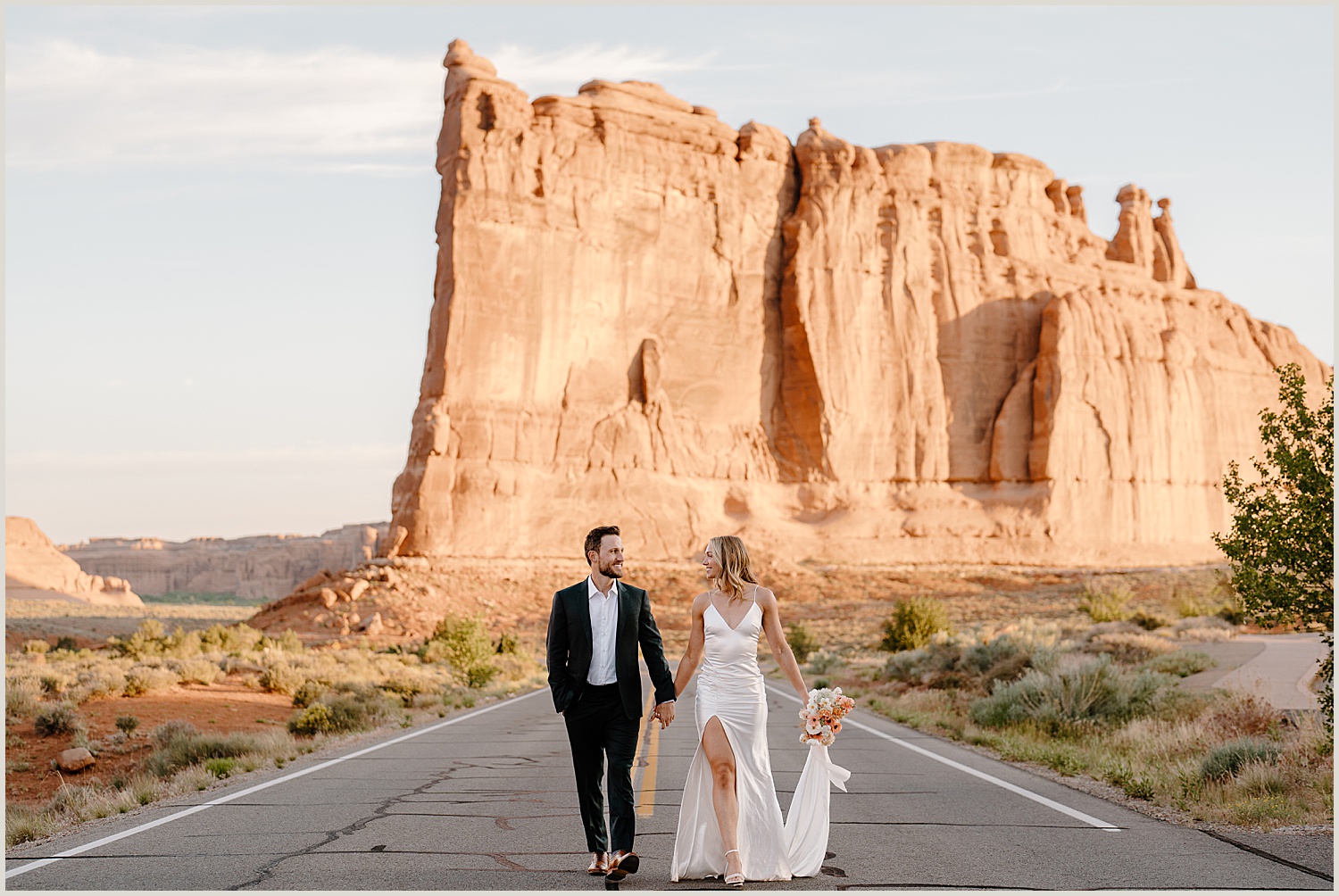 A couple walks through arches national park during their moab elopement day.