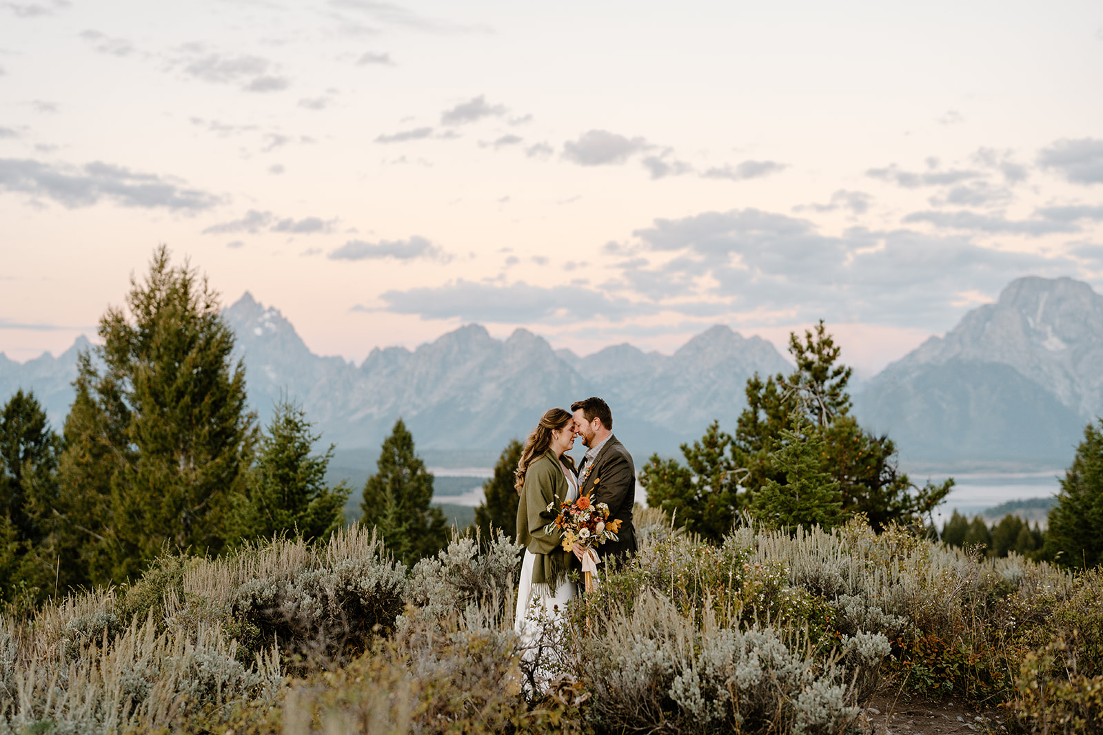 A couple experiences a sunrise elopement ceremony in the majesty of the Grand Tetons.