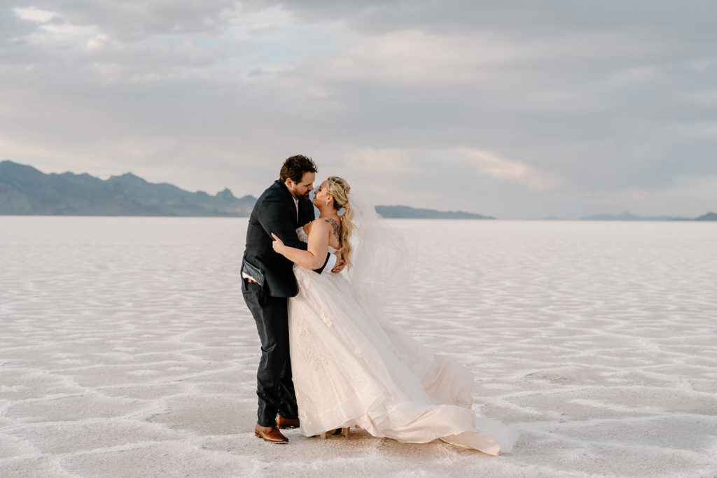 A couple explores the Bonneville salt flats during their sunrise elopement ceremony. 